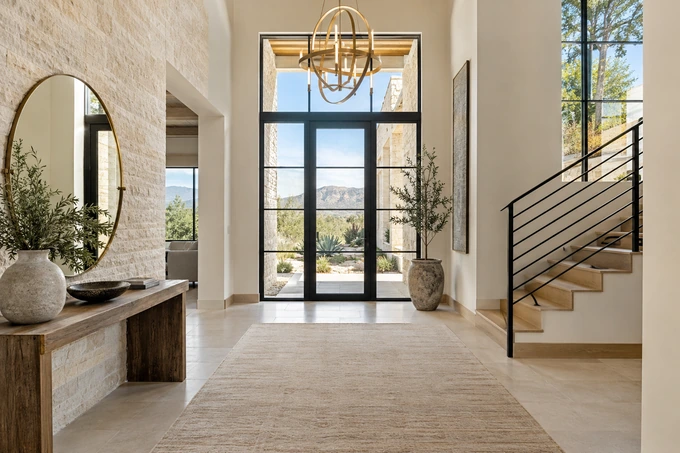 An elegant empty entrance foyer prepared for a property introduction, modern console table and sculptural warm brass light