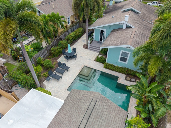 Turquoise home and pool terrace framed by tropical landscaping