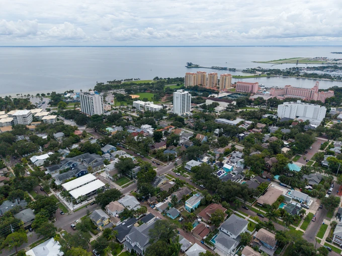 Wide aerial view of a coastal neighborhood and distant shoreline