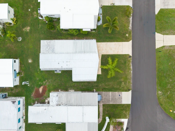 Overhead view of homes, lawns and a straight residential road