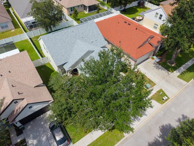Aerial view of neighboring rooflines and leafy front yards