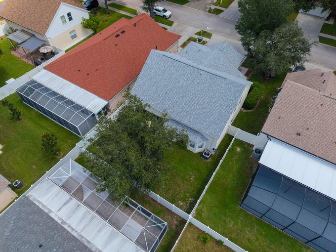 Low aerial view of a home, screened patio and adjoining street